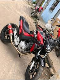 moto tw-250 vermelha em uma estrada de terra